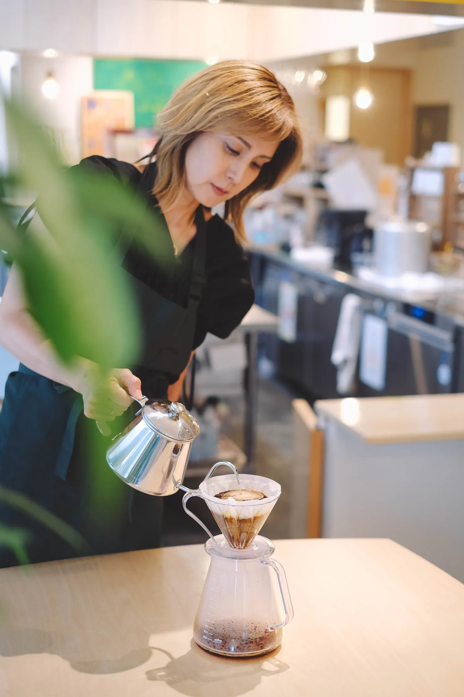 カウンターでハンドドリップコーヒーを淹れるスタッフ